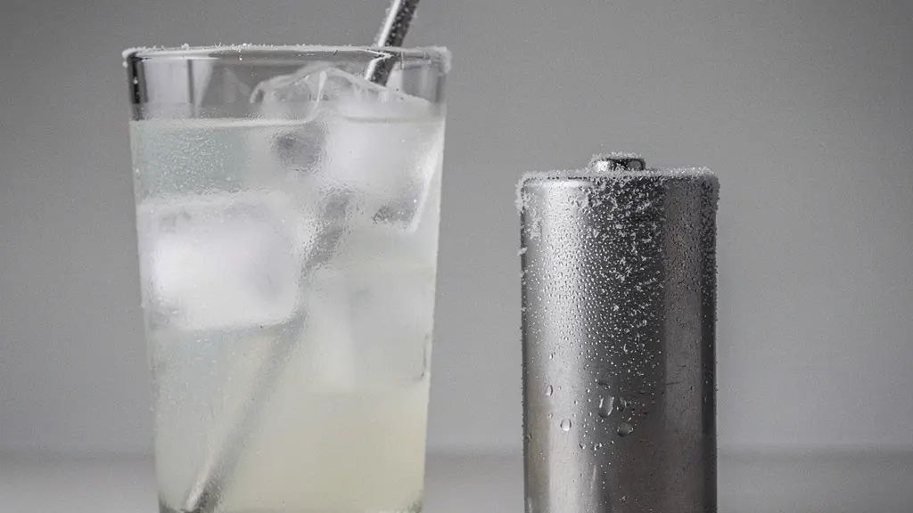Conceptual still life showing a frosty battery-like cylinder beside an iced drink and a narrow straw, symbolizing cold-temperature voltage sag and reduced light output.